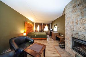 Gjakove卡西亚朱帕弗酒店的酒店客房配有一张床和一个壁炉。