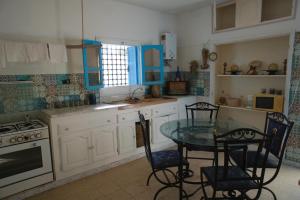 伊里德Wostel Djerba的厨房配有桌椅和炉灶。