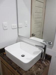 巴耶杜帕尔Hotel Valledupar Plaza的浴室设有白色水槽和镜子