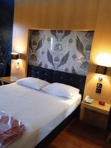 比雷埃夫斯奥林匹克酒店的一间卧室配有一张大床和床头板