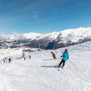 萨莫安斯Samoens 1600, ski au pied的一群人沿着雪覆盖的斜坡滑雪