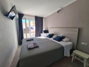 萨科马Amena Mar Hotel的一间卧室配有一张大床和毛巾