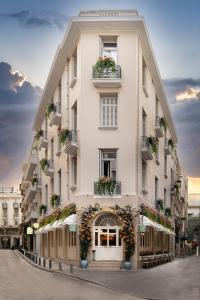 雅典Belle Epoque Suites的一座高大的白色建筑,上面有花盒