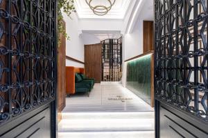 雅典Belle Epoque Suites的走廊设有锻铁门和绿沙发