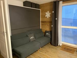 萨莫安斯Samoens 1600, ski au pied的带沙发和大屏幕的客厅