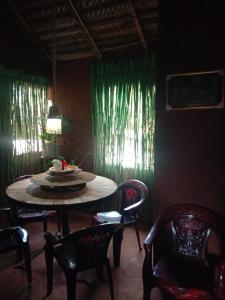 阿努拉德普勒Lucky Holiday Home的用餐室配有桌椅和绿色窗帘