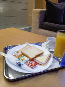 比雷埃夫斯奥林匹克酒店的盘子上放着三明治和一杯橙汁