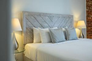 魁北克市皇家港景酒店的卧室配有带两盏灯的白色床