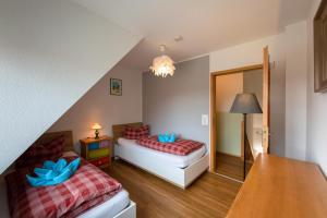 普雷罗DHH 7 Haus am Wiesengrund的一间卧室配有两张床、一张桌子和一盏灯。
