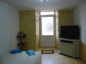 Bourg-ArgentalMeublé Bulgarana - 4 pers的一间卧室设有一张床、一台电视和一个窗口。