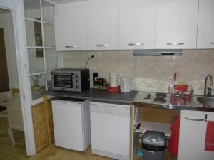 Bourg-ArgentalMeublé Bulgarana - 4 pers的厨房配有白色橱柜和微波炉