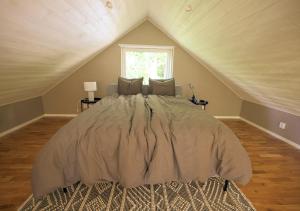 艾尔姆胡尔特Newly built cottage with jacuzzy and sauna的阁楼上的卧室配有一张大床
