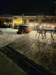 文茨皮尔斯LULU GAST HAUS的雪中在晚上的一张桌子和椅子