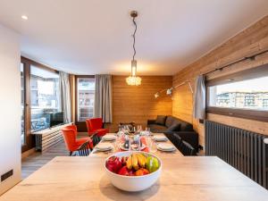 蒂涅Apartment Le Pramecou - Val Claret-8 by Interhome的用餐室,配有一张桌子,上面放着一碗水果