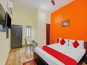 布巴内什瓦尔OYO Flagship Hotel Greenmoods的一间卧室配有一张橙色墙壁的床