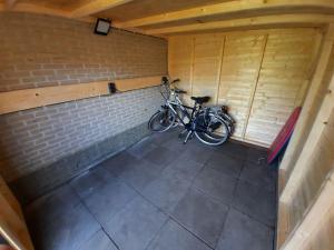 EernewoudeHoliday Home Bungalowpark It Wiid的停放在砖墙房中的自行车
