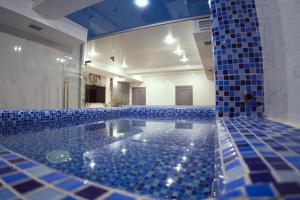 奇姆肯特Shymkent Park Hotel的浴室设有蓝色瓷砖大浴缸