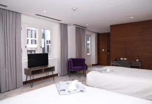 巴拿马城Hotel San Felipe的酒店客房设有两张床和一台平面电视。