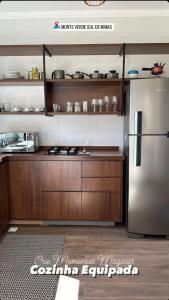 蒙特韦尔迪Chales Campestre Monte Verde - 150 mts do Centro的厨房配有不锈钢冰箱和木制橱柜