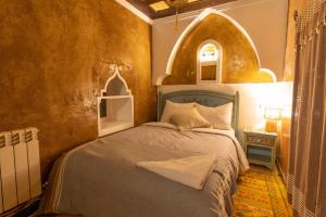 凯拉Kasbah Assafar的一间带一张床铺的卧室,位于带拱门的房间
