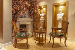 伊斯坦布尔Lord Morgan & Exclusive Design Cihangir的一间设有两座雕像和两把椅子的房间和一个壁炉