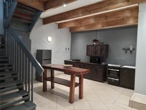 霍维克Howick Greendale 4 Self Catering Units Solar & Battery Back-Up的厨房设有木桌和楼梯。