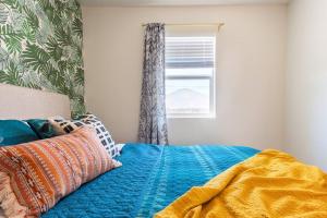 圣地亚哥Casita Amarilla, Tiny House的一张带蓝色毯子和窗户的床
