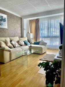 雷乌斯Premium Aparthotel-PortAventura, FerrariLand,tren的带沙发和玻璃桌的客厅