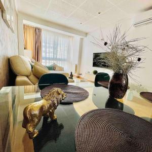 雷乌斯Premium Aparthotel-PortAventura, FerrariLand,tren的客厅,玻璃桌上摆放着狗雕像