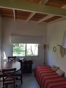 科隆El Sosiego Posada de Campo的一间卧室配有一张床、一张书桌和一个窗户。