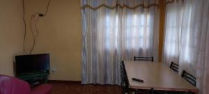 Puerto LibertadEl Amanecer Don Zenon Lago Urugua-i的客厅配有桌子、电视和窗帘