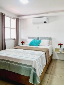 瓜拉派瑞Estada Inesquecível 18 Guarapari的一间卧室配有一张带蓝色枕头的大床