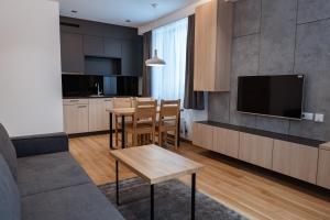 亚霍里纳Aparthotel Zlatni Javor的厨房以及带桌子和电视的客厅。