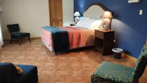 San Lucas SacatepéquezCasa Hacienda Santo Domingo的配有一张床和一把椅子的酒店客房