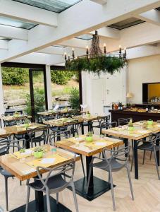 阿尔巴艾格日特日斯莫麦玛酒店的餐厅设有木桌、椅子和吊灯。