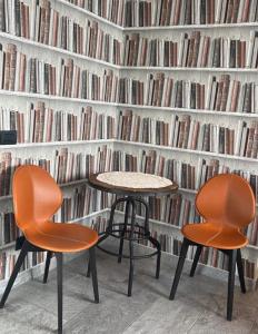 阿尔巴艾格日特日斯莫麦玛酒店的两把椅子和一张桌子,放在书墙前