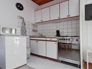 维甘Sea-view Apartments Klara - Viganj的厨房配有白色橱柜、炉灶和冰箱。