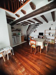 安圭拉萨巴齐亚Chalet Romantico Sul Lago的一间带桌椅和楼梯的客厅