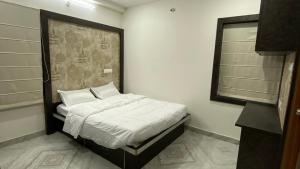 海得拉巴Ahasa Bacardi的一间卧室配有一张带白色床单的床和一扇窗户。