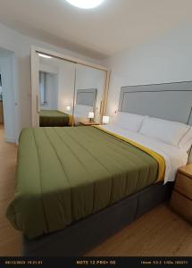 毕尔巴鄂Bonito Apartamento en Zamakola的卧室内的一张大床,配有大镜子