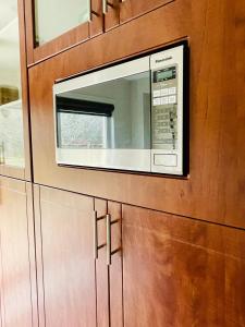 惠特比Homestay- private room and bathroom的厨房的木柜里有一个微波炉