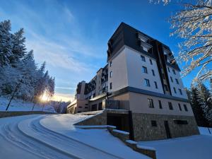 亚霍里纳Aparthotel Zlatni Javor的雪覆盖道路上的一座建筑物