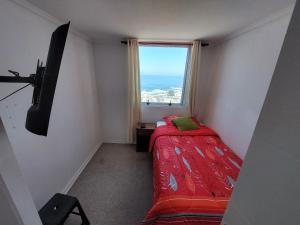 伊基克LABBE Departamento Hermosa Vista al Mar的一间小卧室,配有床和窗户