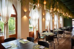雷卡纳蒂Hotel Ristorante La Ginestra的用餐室设有桌椅和窗户。