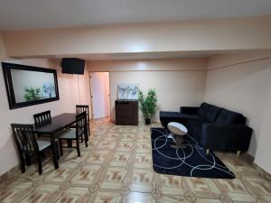 Alto HospicioHotel La Pampa的客厅配有黑色沙发和桌子