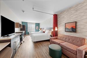 圣贝纳迪诺Home2 Suites By Hilton San Bernardino的酒店客房设有一张沙发和一张床