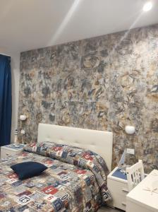 尼科洛西B&B La Grotta的一间卧室设有一张床和石墙