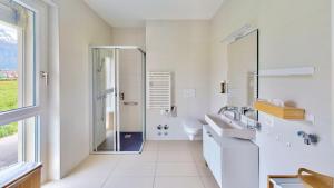 CollombeyAlp Art Hotel的带淋浴和盥洗盆的白色浴室