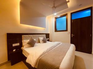 哈里瓦The Ganga Divine - A Family Hotel的卧室配有一张带白色床单和枕头的大床。