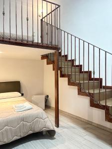那不勒斯House Caracciolo的一间卧室设有一张床和一个楼梯